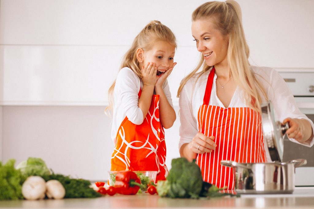 Mother And Daughter Cooking At The Kitchen